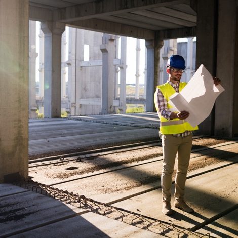 Hopkins Consultants industry areas represented by image of worker are development site looking at plan